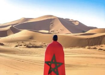 Sahara Desert sand dunes in Morocco with camel caravan at sunset